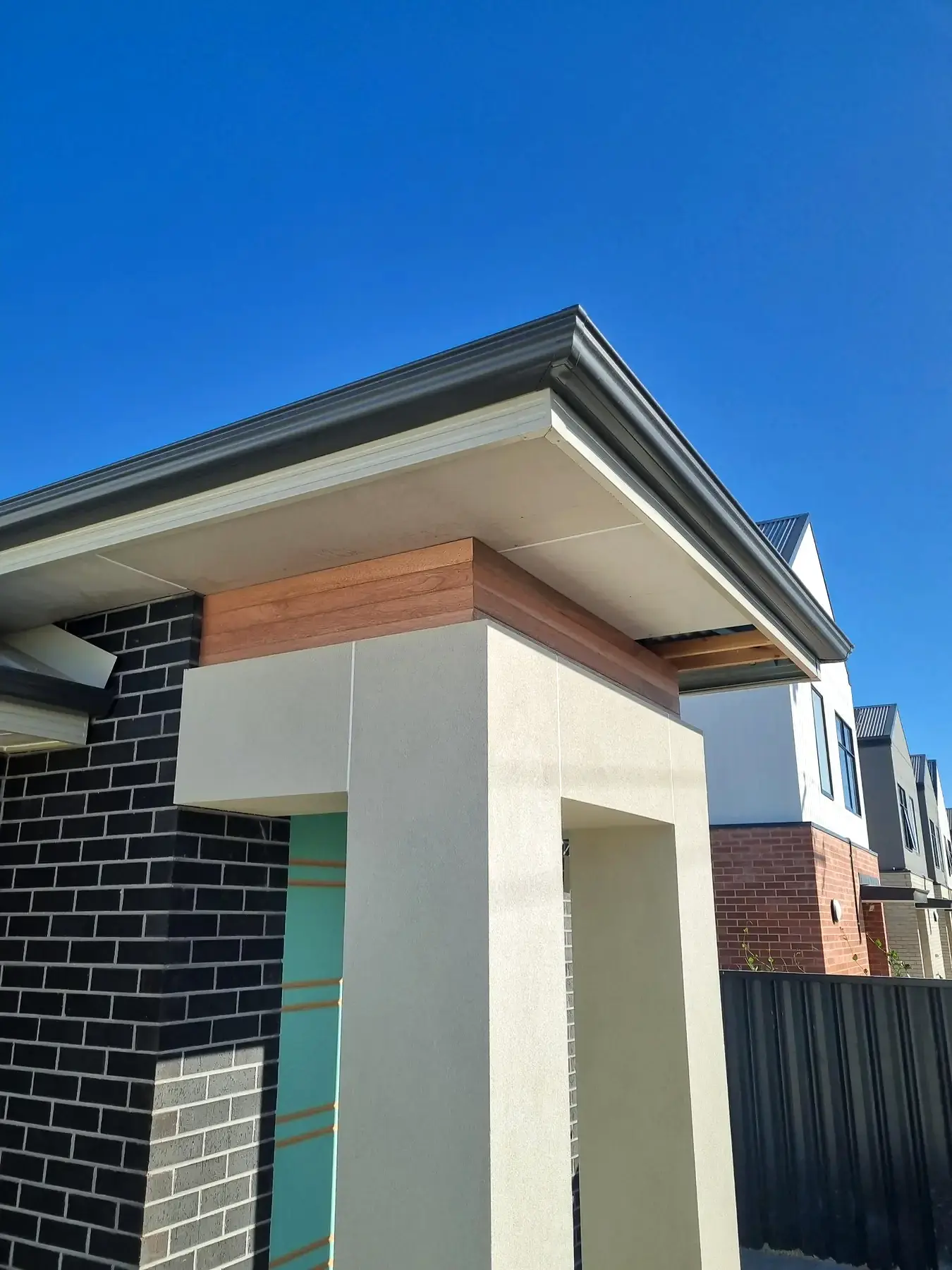 Finished timber-clad entry portal against a crisp rendered facade