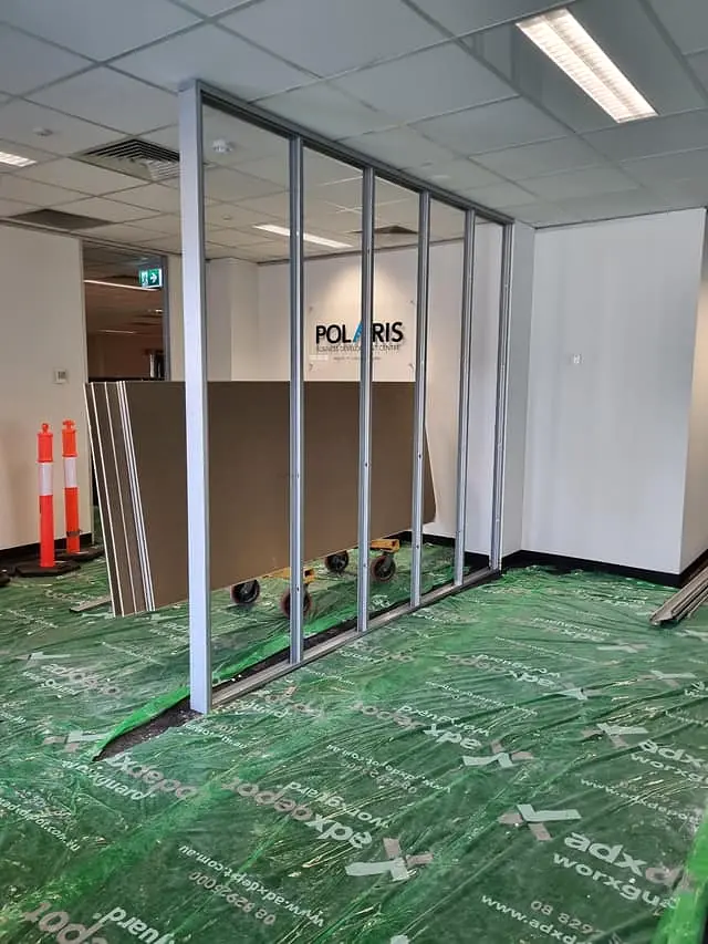 Steel partition framing erected across the office floor