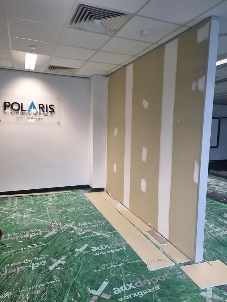 Steel-framed partition walls being lined in a commercial office fit-out