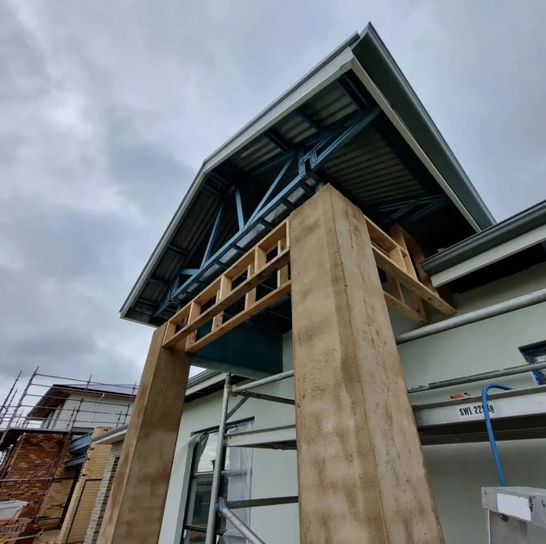 The entry portico framing, showing the steel roof structure and timber gable framing